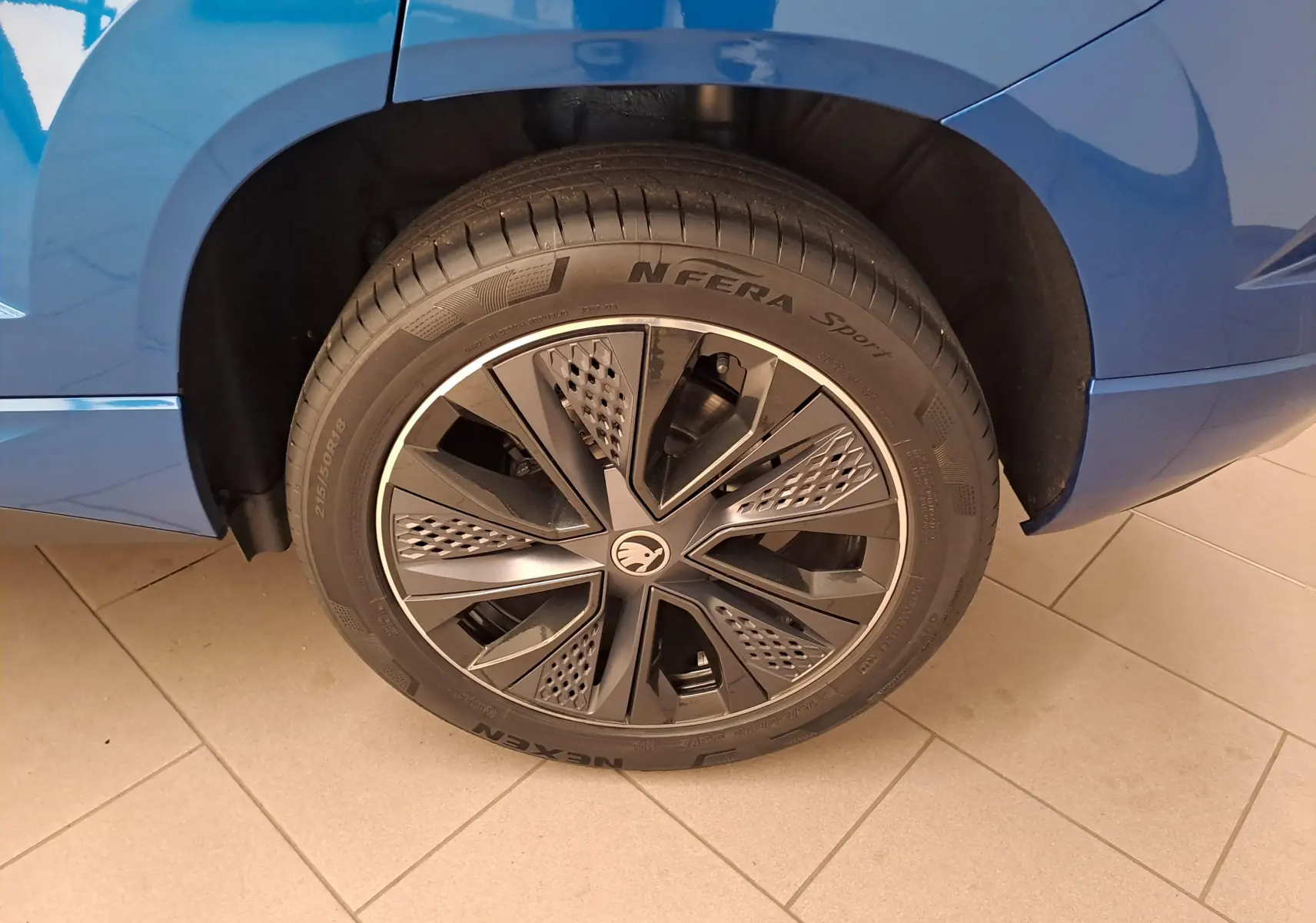 Gros plan sur la roue arrière droite du SKODA KAROQ Bleu RS 2025 avec jante noire au design moderne.