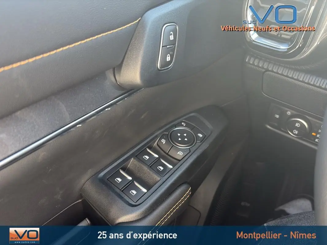 Gros plan sur les commandes des vitres électriques et verrouillage sur la porte côté conducteur du Ford Ranger noir 2025.