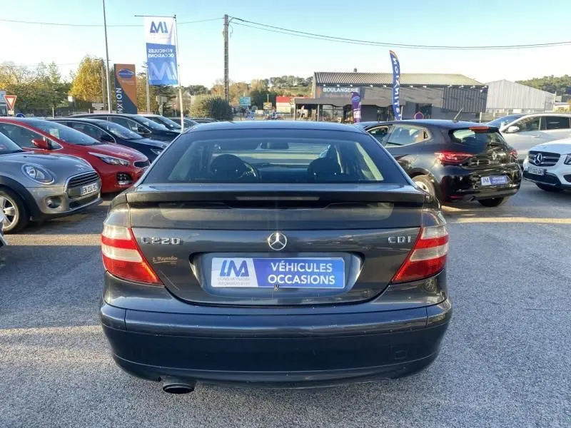 Vue arrière d'une Mercedes Classe C Coupé Sport 220 CDI gris foncé métal, avec son aileron et plaques d'occasion visibles.