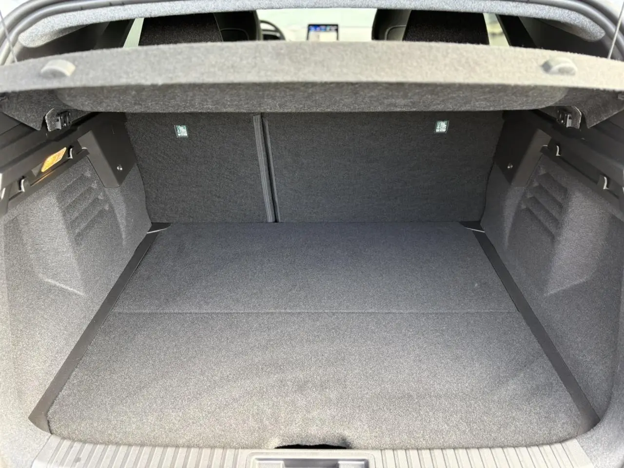 Coffre ouvert de la Renault Symbioz gris Rafale, montrant un espace de chargement propre et tapissé de tissu gris.