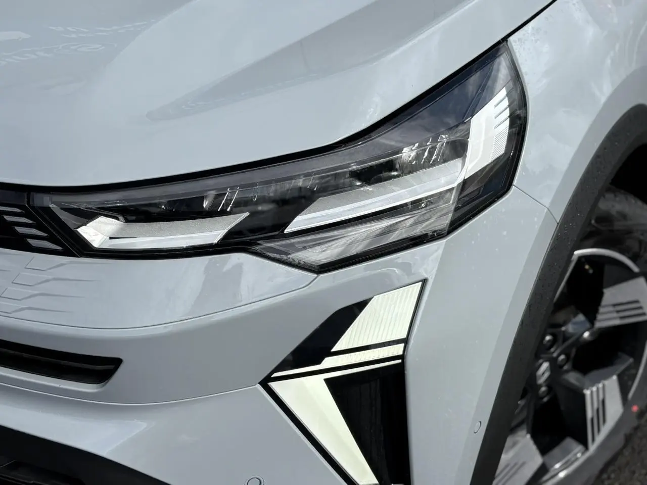 Gros plan sur le phare avant droit du Renault Symbioz gris Rafale avec signature lumineuse LED distinctive.