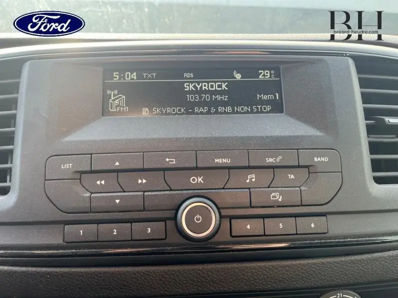 Tableau de bord du Peugeot Expert Fourgon blanc, affichant la radio Skyrock sur écran central noir.