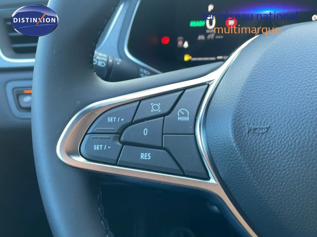 Gros plan sur les commandes au volant du Renault Captur blanc nacré avec toit noir, version hybride 2025.