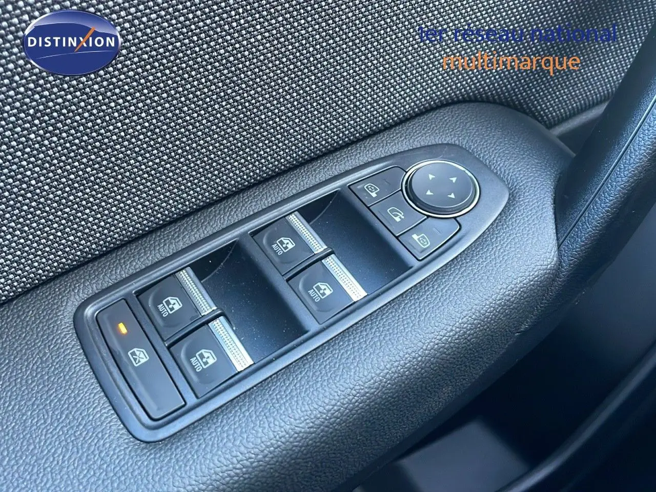 Gros plan sur les commandes des vitres électriques côté conducteur du Renault Captur blanc nacré 2025.