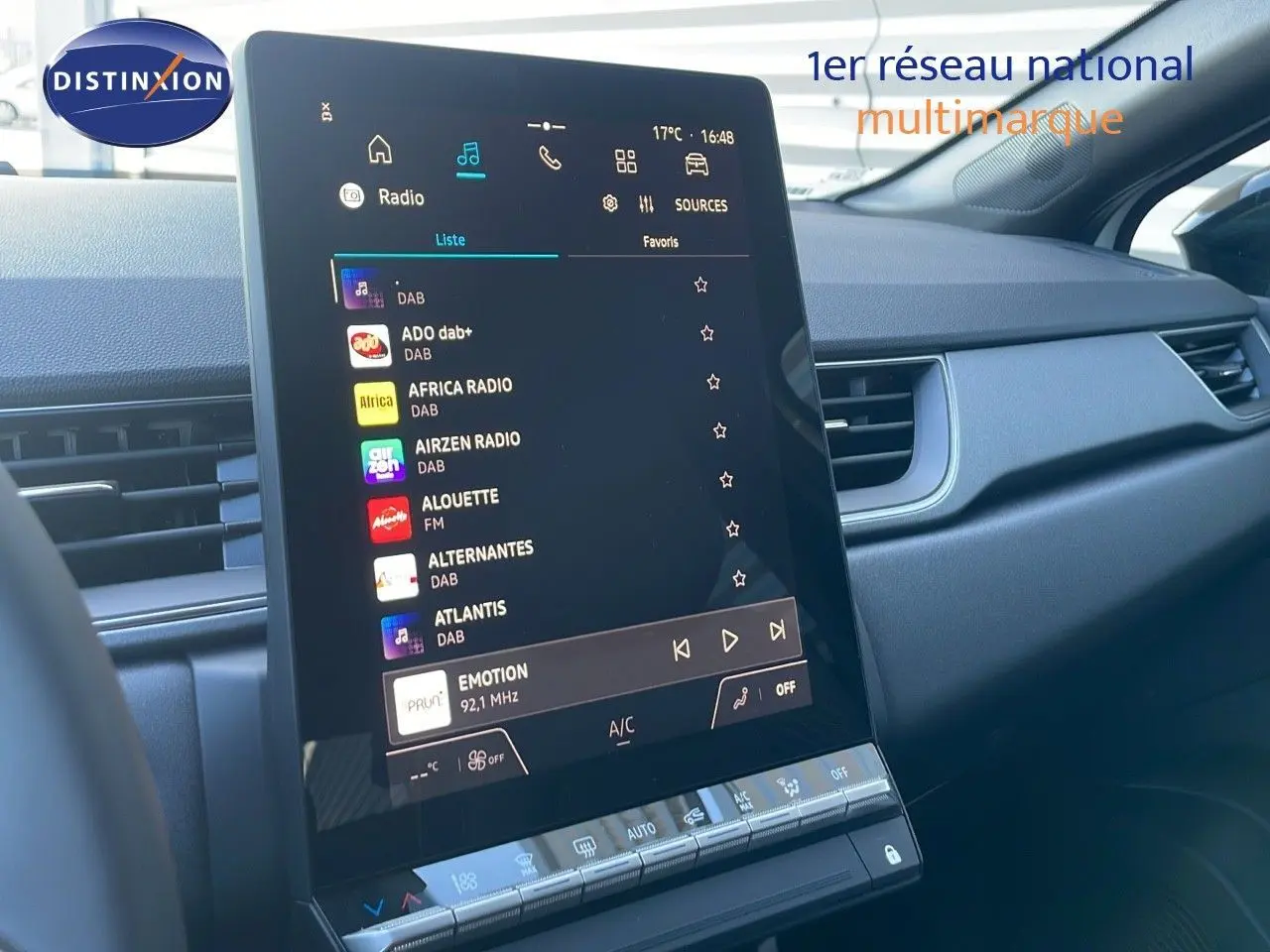 Écran tactile central du tableau de bord du Renault Captur E-Tech blanc nacré, affichant la liste des radios DAB.