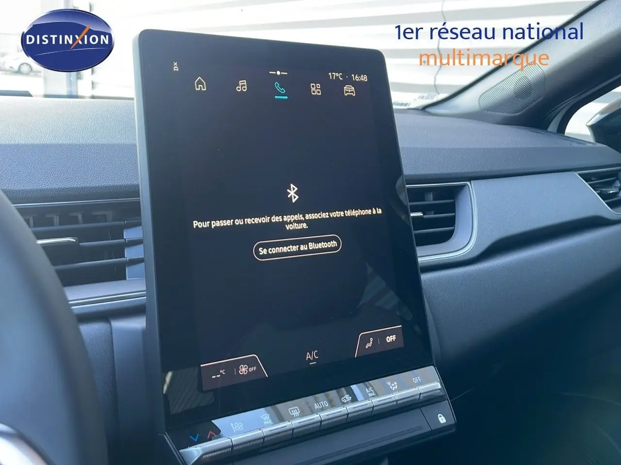Écran tactile central du tableau de bord du Renault Captur E-Tech blanc nacré avec toit noir, vue intérieure côté passager.