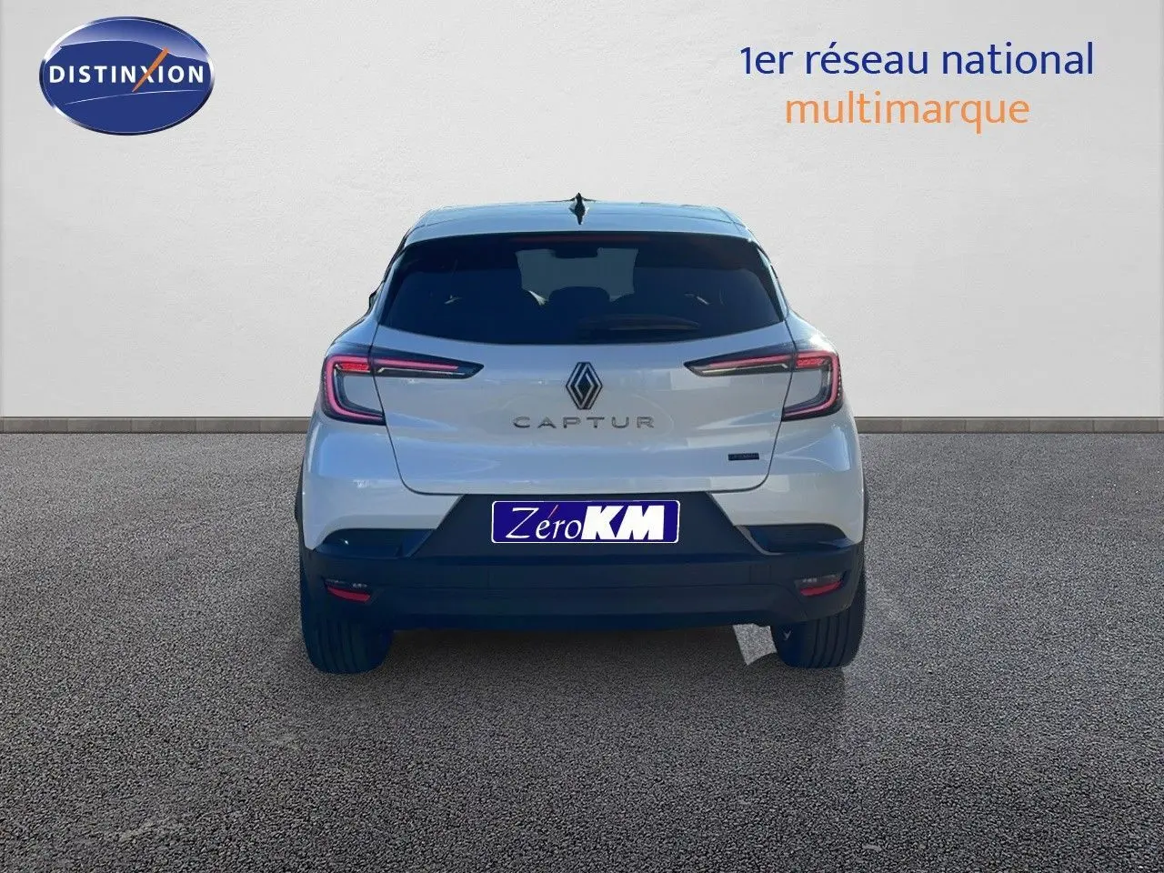 Vue arrière du Renault Captur E-Tech hybride blanc nacré avec toit noir, mettant en valeur ses feux LED fins et son logo central.