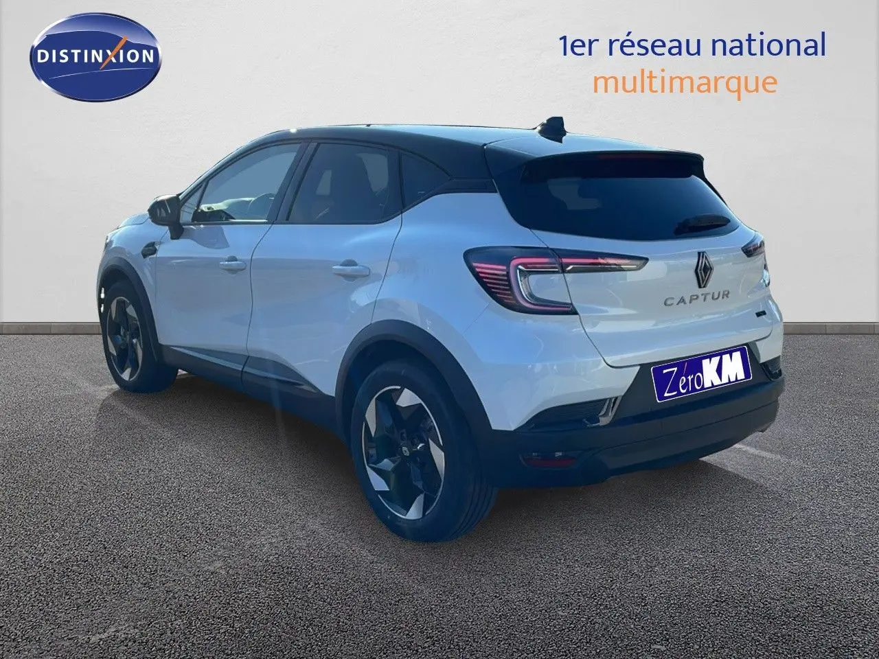 Renault Captur E-Tech hybride blanc nacré avec toit noir, vue 3/4 arrière côté gauche, jantes noires distinctives.