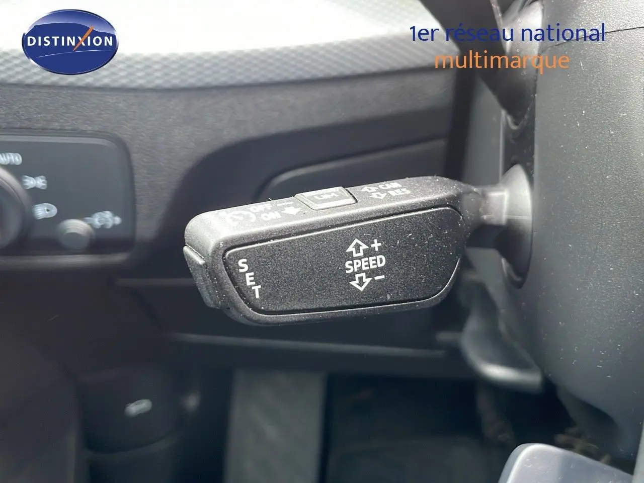 Gros plan sur le levier de régulateur de vitesse à gauche du volant dans l'Audi Q2 noir mito metal 2023.