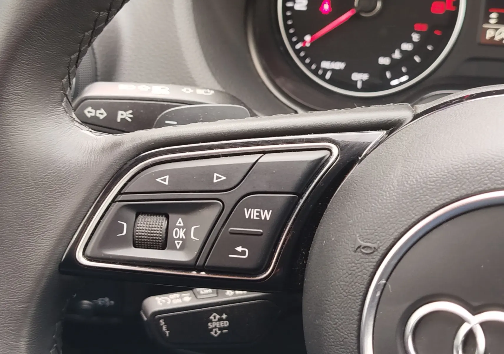 Gros plan sur la console centrale de l'Audi Q2 35 TFSI S-Line 2023, montrant les commandes de climatisation et prises USB.