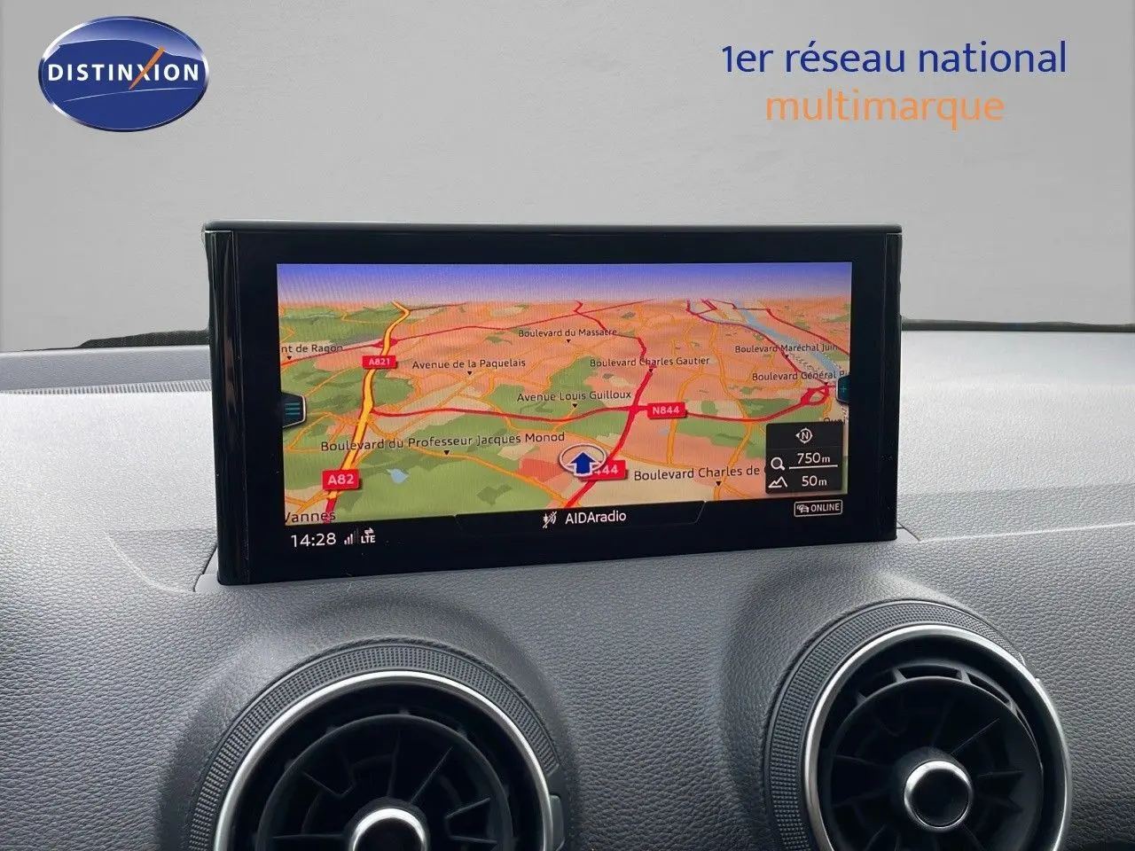 Vue avant rapprochée du tableau de bord de l'Audi Q2 noir mito metal avec écran GPS et aérateurs ronds.