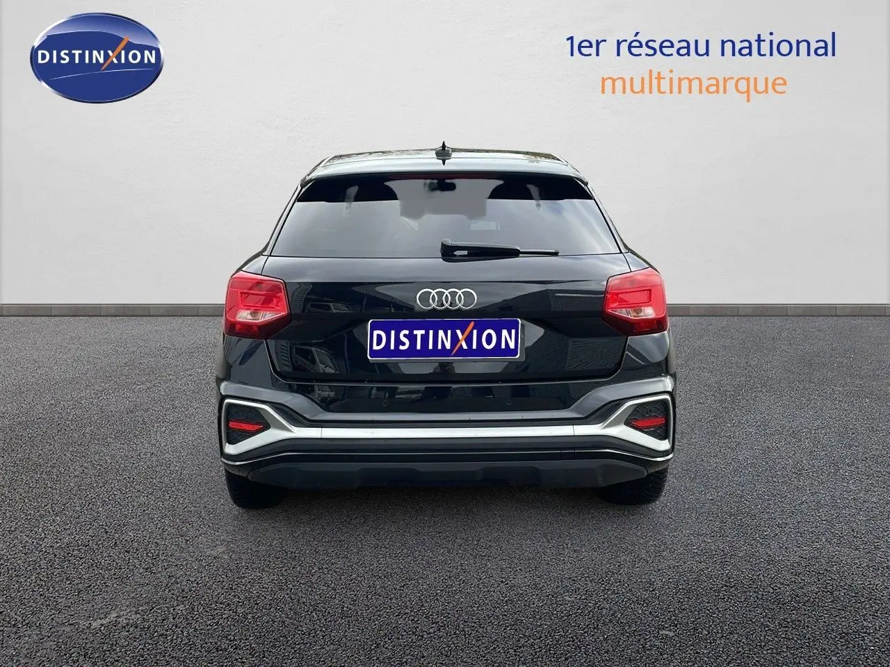 Vue arrière d'un Audi Q2 noir mito metal 2023 avec feux rouges et détails argentés sur le pare-chocs.