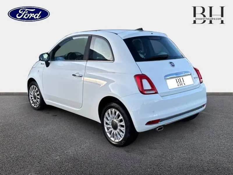 Vue 3/4 arrière droite d'une Fiat 500 blanche Bossa Nova avec jantes alu et feux arrière rouges.