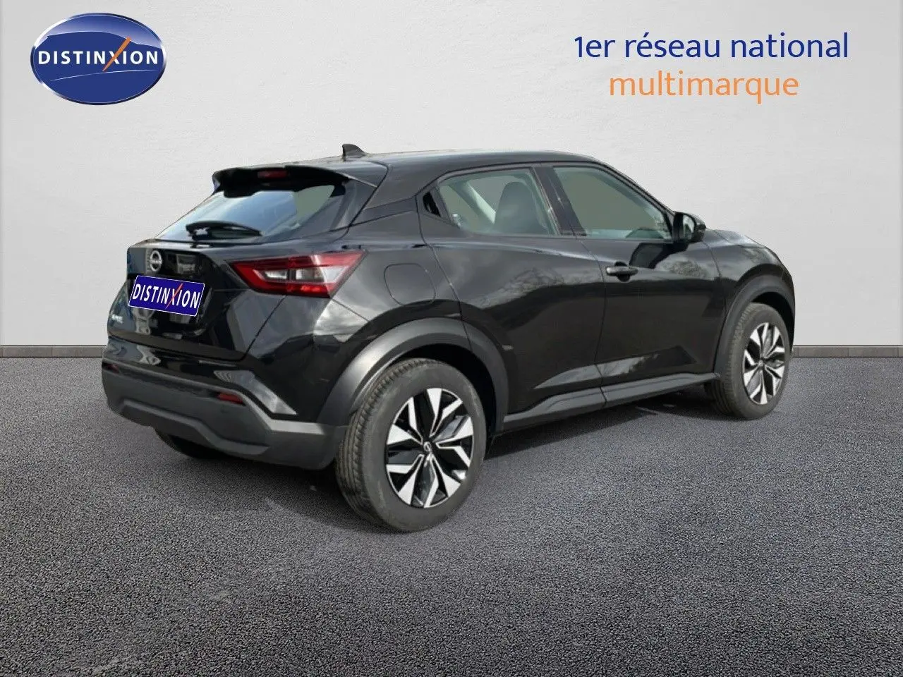 Vue 3/4 arrière droite d'un Nissan Juke noir perle métal 2023 avec jantes alliage et lignes dynamiques.