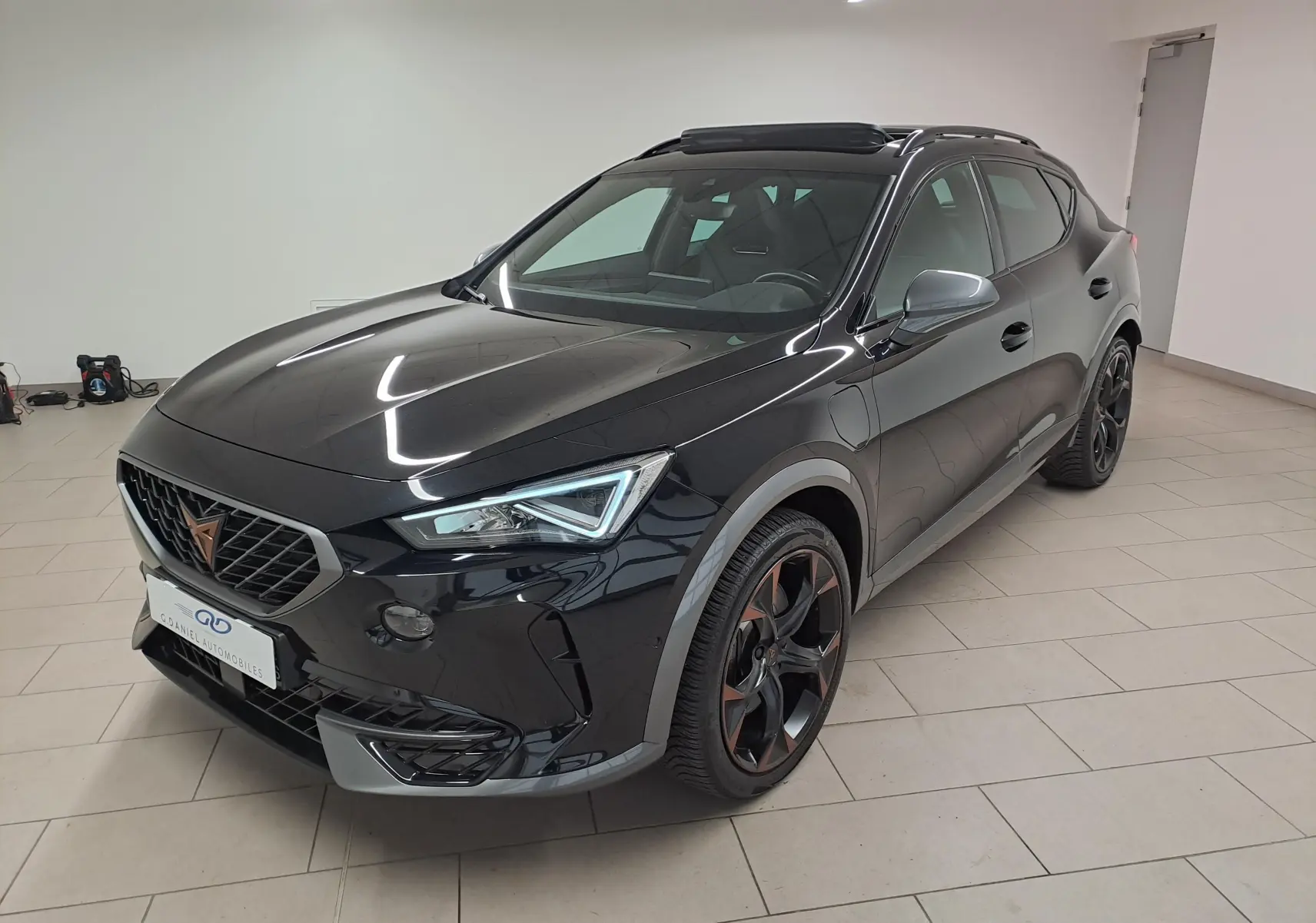 Vue 3/4 avant droite du CUPRA Formentor 1.4 e-HYBRID 2023 noir minuit avec jantes noires et toit ouvrant panoramique.