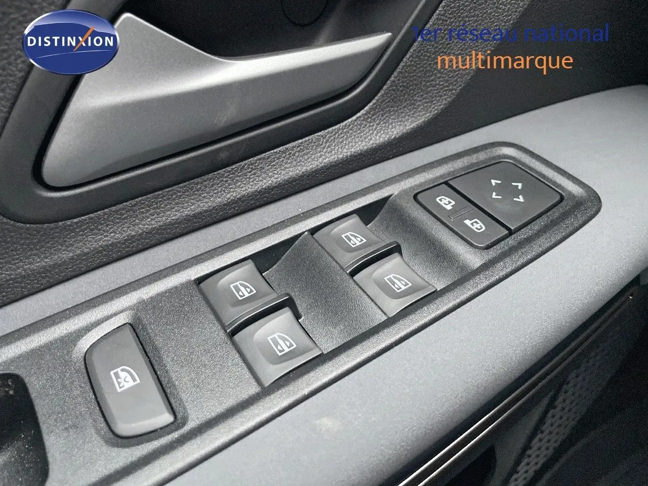 Gros plan sur les commandes des vitres électriques côté conducteur du Dacia Jogger gris schiste métal, intérieur noir.