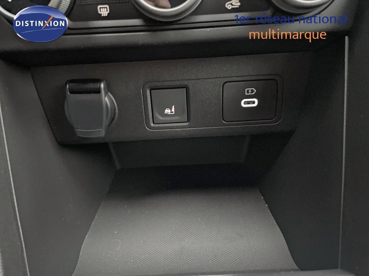 Détail de la console centrale avec prise 12V, bouton d'assistance au démarrage en côte et port USB-C sur Dacia Jogger gris schiste métal.