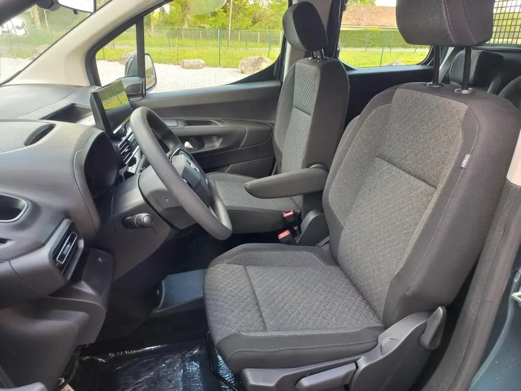 Vue intérieure côté conducteur de l’Opel Combo Life Elegance M 2025 bleu, sièges tissu gris avec accoudoir et écran tactile.