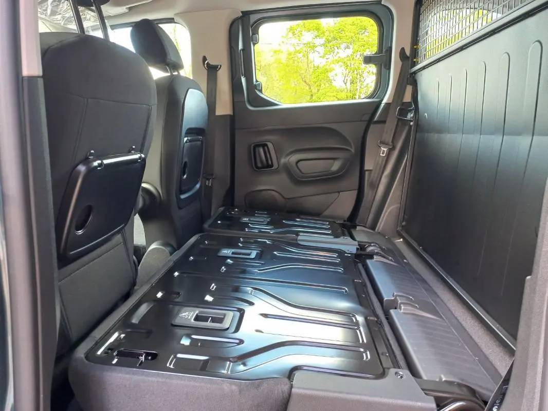 Vue intérieure côté droit de l’Opel Combo LIFE Elegance M 2025 bleu, sièges arrière rabattus et plancher de chargement visible.