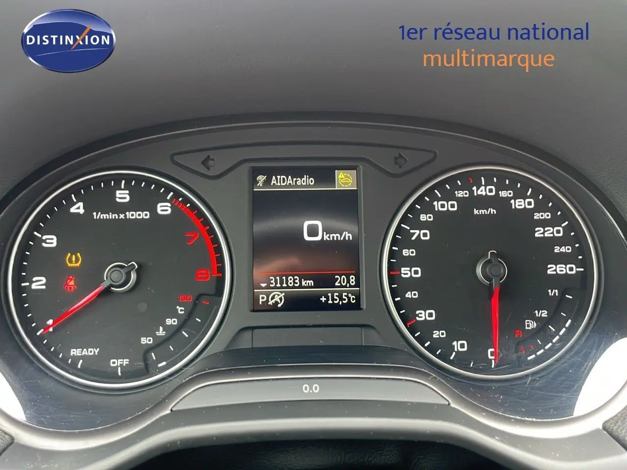 Vue rapprochée du tableau de bord de l'Audi Q2 noir, affichant compte-tours, vitesse et écran central numérique.