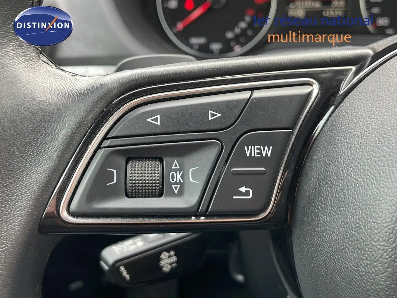 Gros plan sur les commandes multifonctions du volant en cuir noir de l'Audi Q2 35 TFSI S-Line 2023.