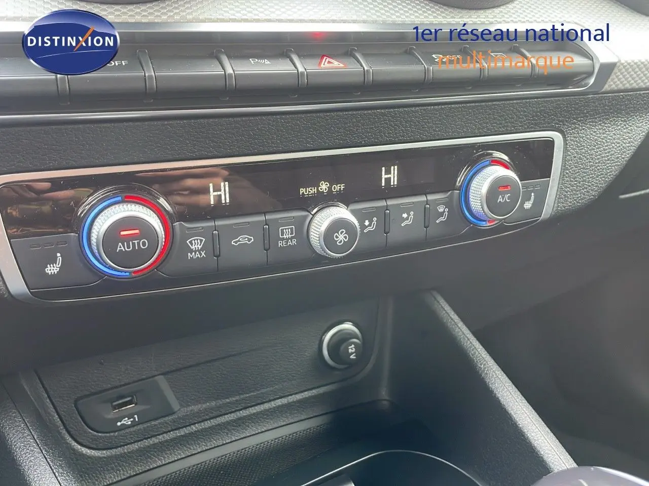 Détail de la console centrale avec commandes de climatisation et prise USB de l'Audi Q2 noir mito metal 2023.