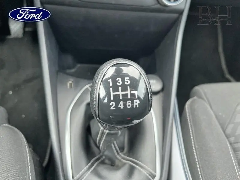 Gros plan sur le levier de vitesses manuel noir de la Ford Fiesta Titanium Business blanche, intérieur tissu noir.