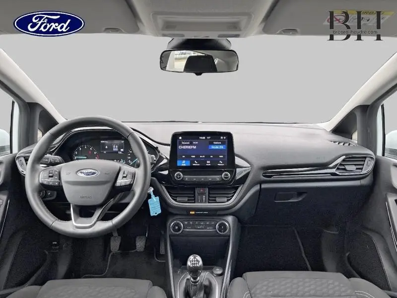 Vue frontale de l'habitacle noir de la Ford Fiesta Titanium 2022 avec volant cuir et écran tactile central.