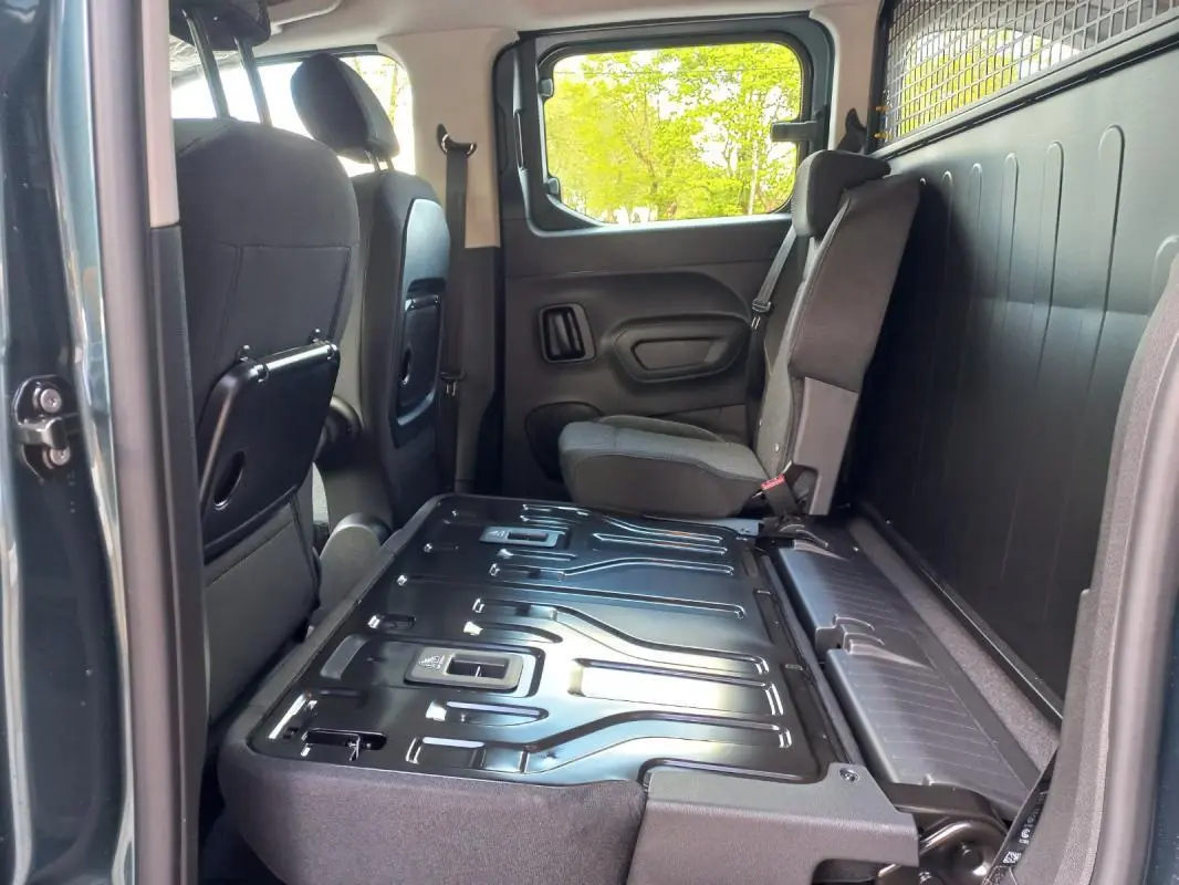 Vue intérieure côté droit de l’Opel Combo Life 2025 bleu, montrant la banquette arrière rabattue et les sièges avant.