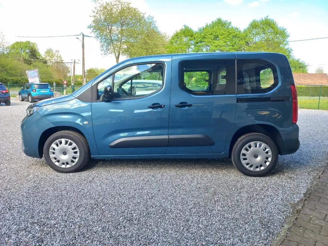 Vue de profil côté gauche d’un Opel Combo Life bleu 2025 avec portes coulissantes et jantes acier.