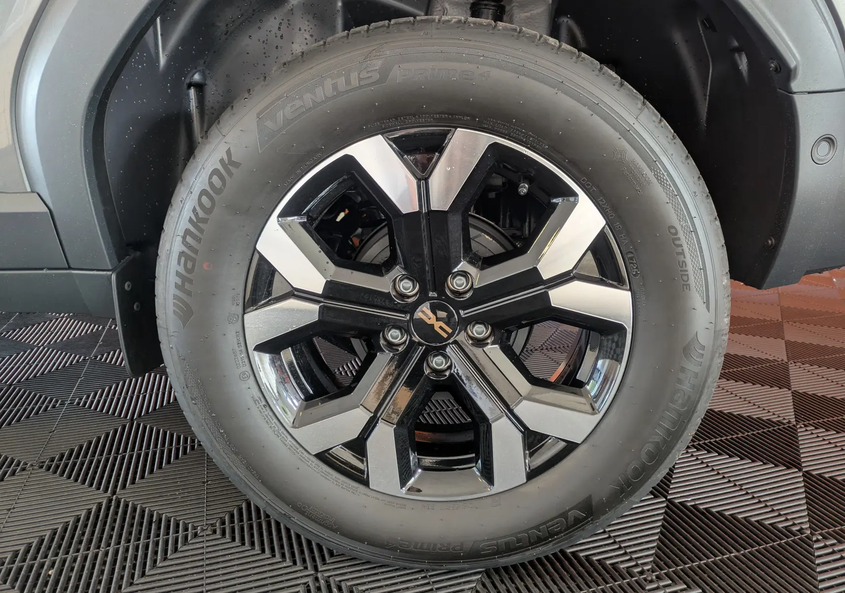 Gros plan sur la jante bi-ton noire et argent du Dacia Duster 1.6 Hybrid 140 Extreme gris schiste, avec pneu Hankook Ventus.