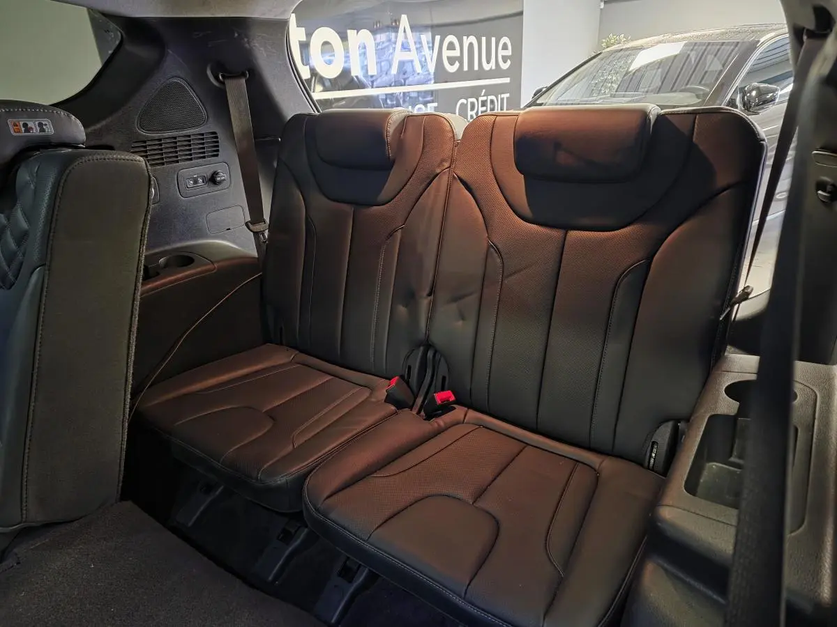 Vue intérieure du troisième rang de sièges en cuir noir du Hyundai Santa Fé 2023, avec appuie-têtes et ceintures visibles.