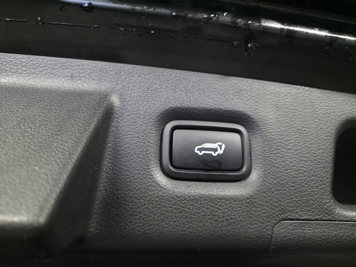 Bouton d'ouverture électrique du hayon sur le panneau intérieur du coffre du Hyundai Santa Fé noir 2023.
