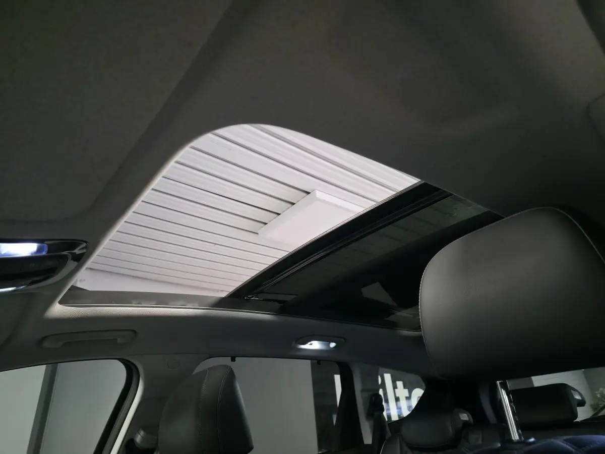 Toit ouvrant panoramique ouvert vu de l'intérieur du Hyundai Santa Fé 2023 avec sellerie cuir noire