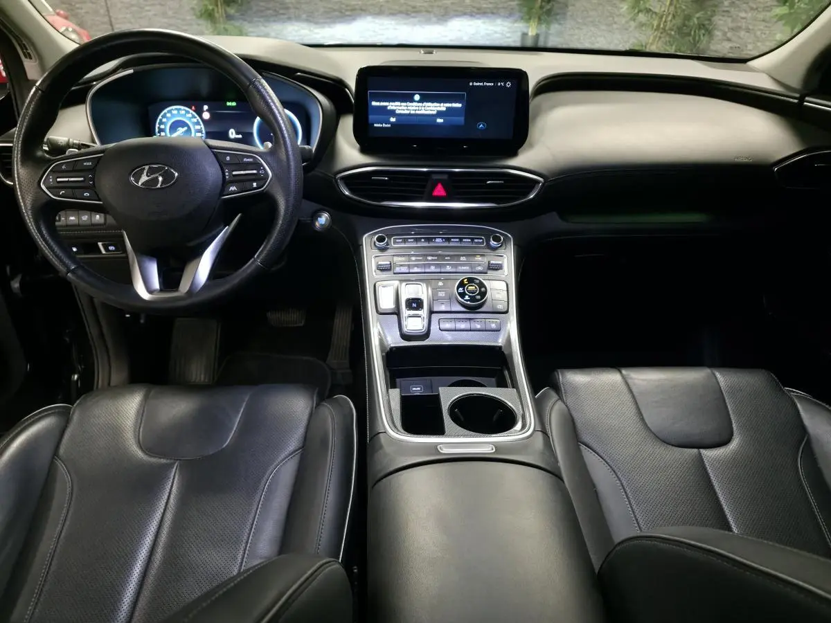 Intérieur noir du Hyundai Santa Fé 2023 vu de face, avec tableau de bord numérique et console centrale moderne.