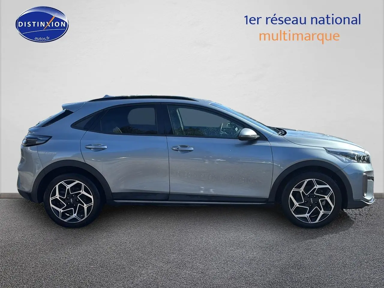 Profil droit d'un KIA Xceed gris 2024 avec jantes alu au design géométrique et vitres arrière surteintées.