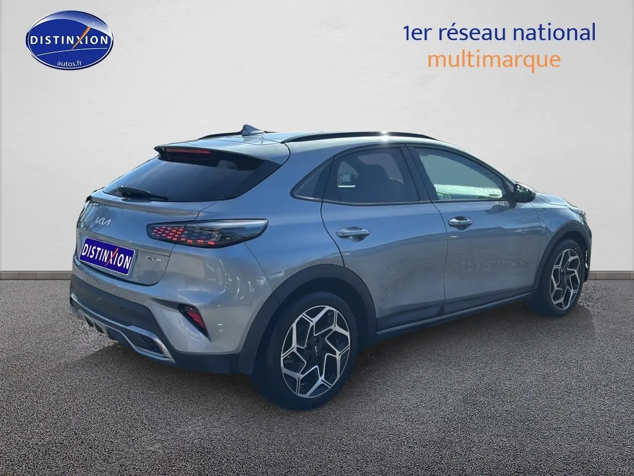 Vue 3/4 arrière droite d'un KIA Xceed gris 2024 avec jantes alu et feux arrière LED distinctifs.