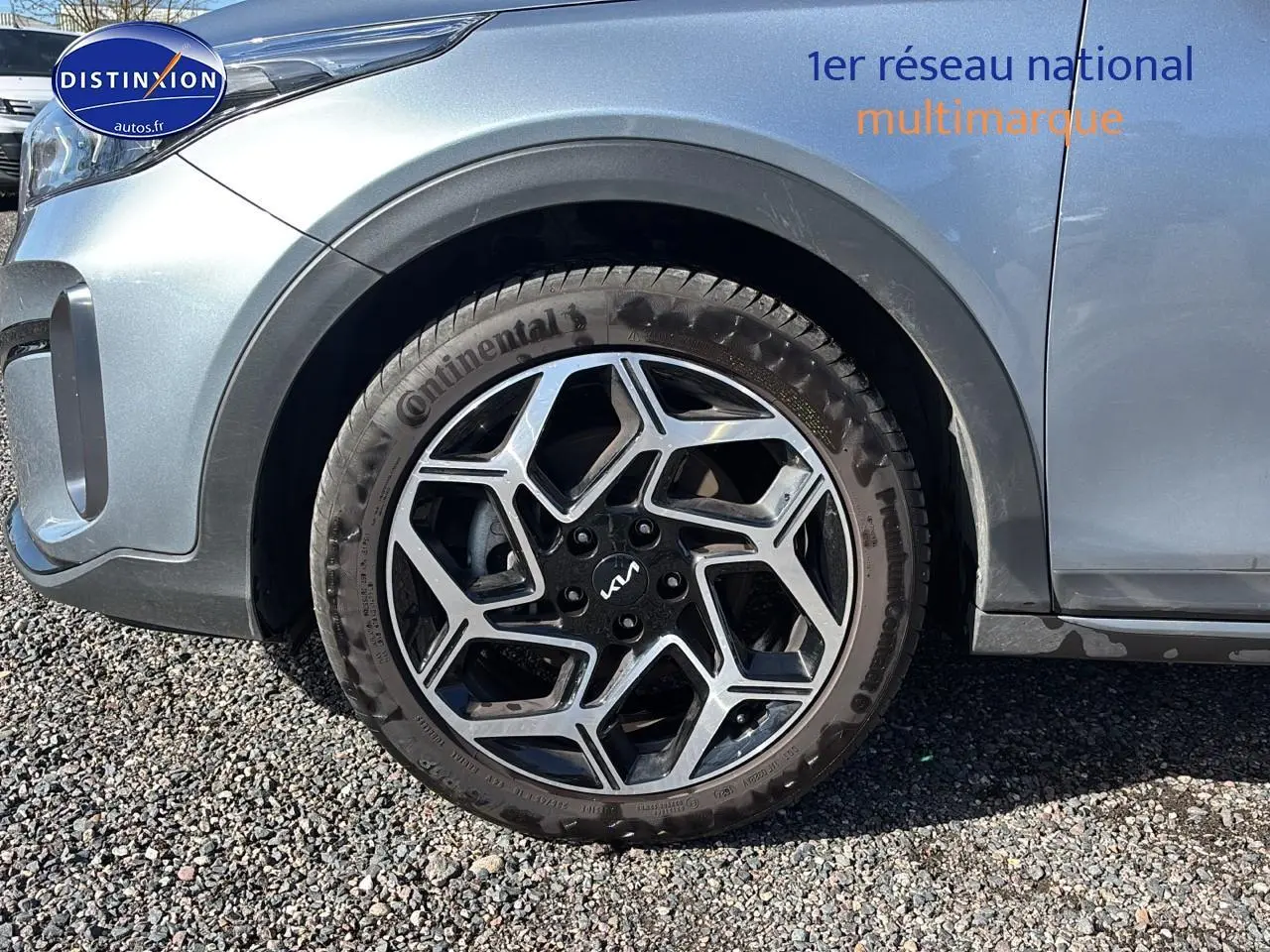 Gros plan sur la roue avant gauche avec jante alu noire et argentée d’une KIA Xceed gris métallisé.