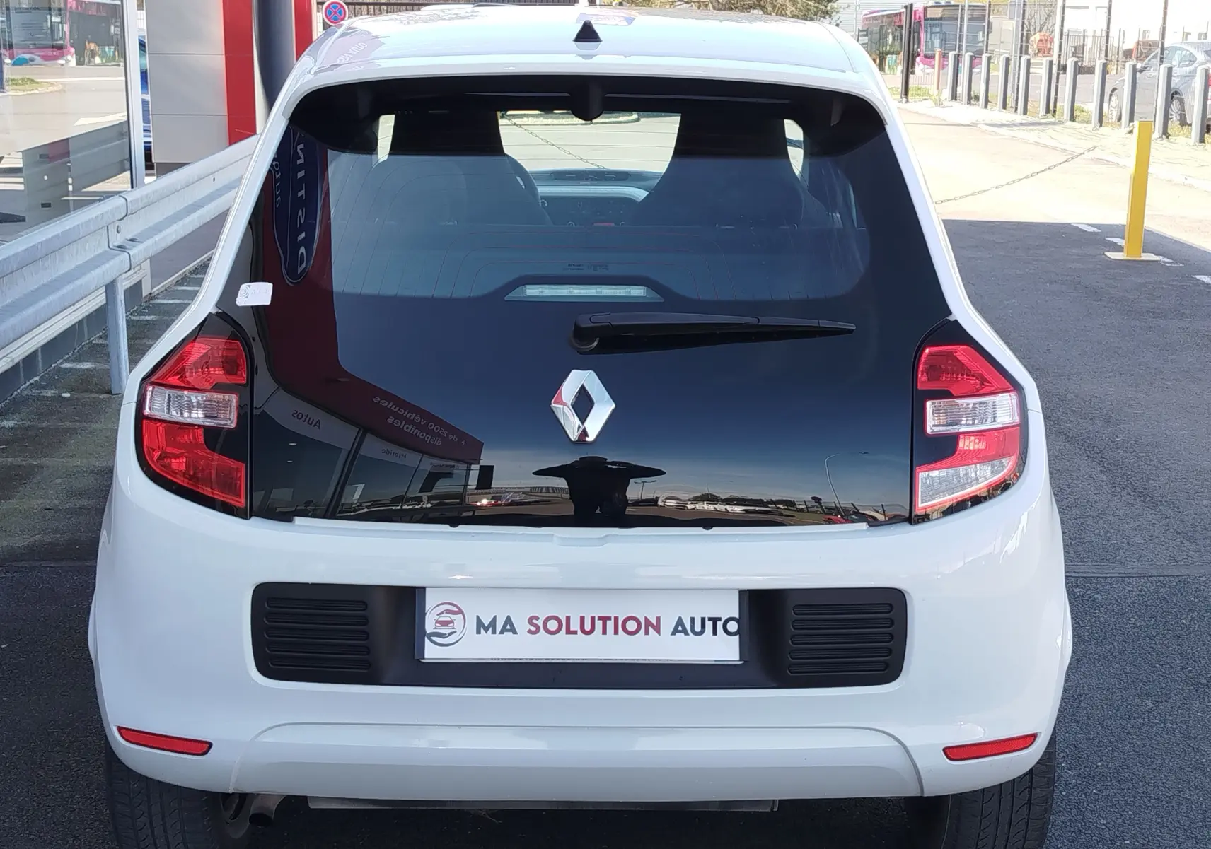 Vue arrière d'une Renault Twingo Blanc Cristal de 2016 avec lunette arrière noire et feux arrière distinctifs.