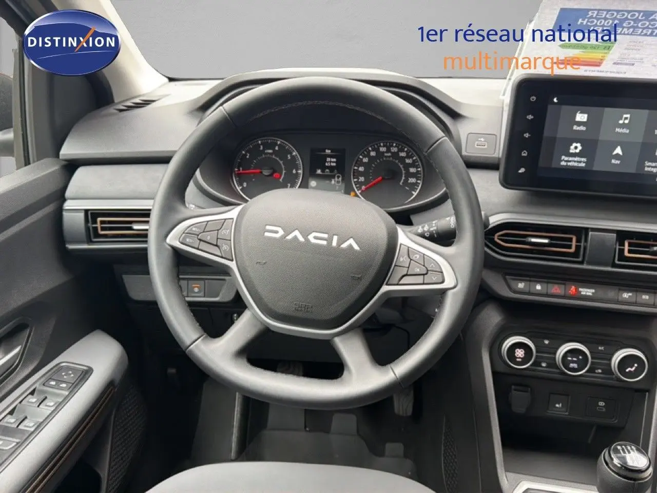 Vue intérieure centrée sur le volant DACIA du Jogger 2026, tableau de bord et écran tactile visibles, ambiance sobre et fonctionnelle.