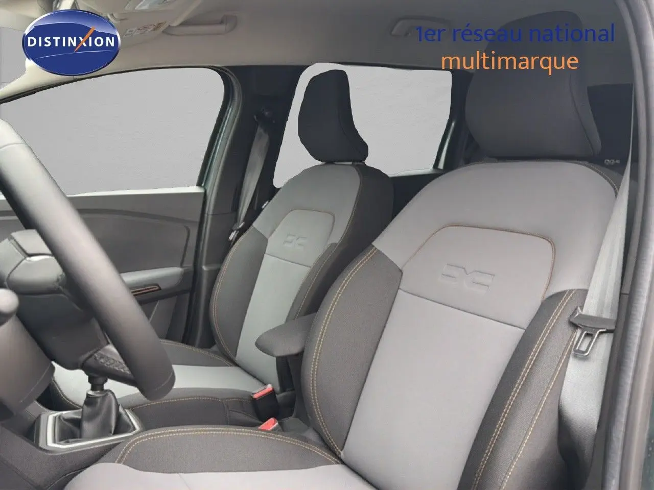 Vue intérieure côté conducteur du Dacia Jogger 2026, sièges tissu gris clair et foncé avec surpiqûres contrastantes.