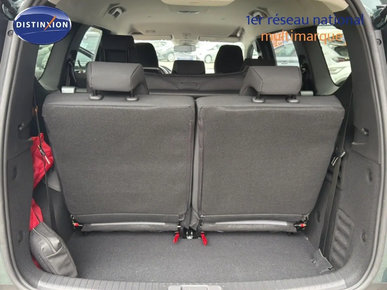 Vue arrière du coffre du Dacia Jogger vert cèdre, sièges arrière relevés et espace de chargement visible.