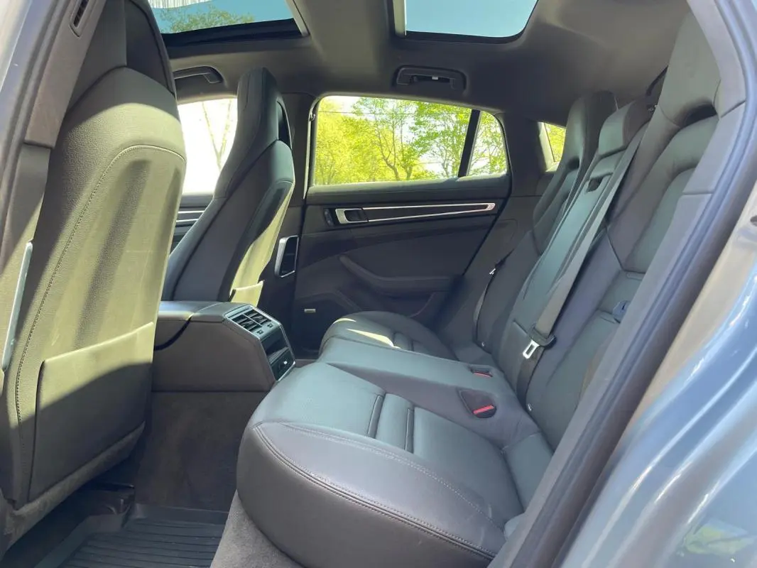 Vue intérieure arrière côté droit de la Porsche Panamera 4 V6 3.0 Hybrid gris, sièges cuir et toit panoramique ouverts.