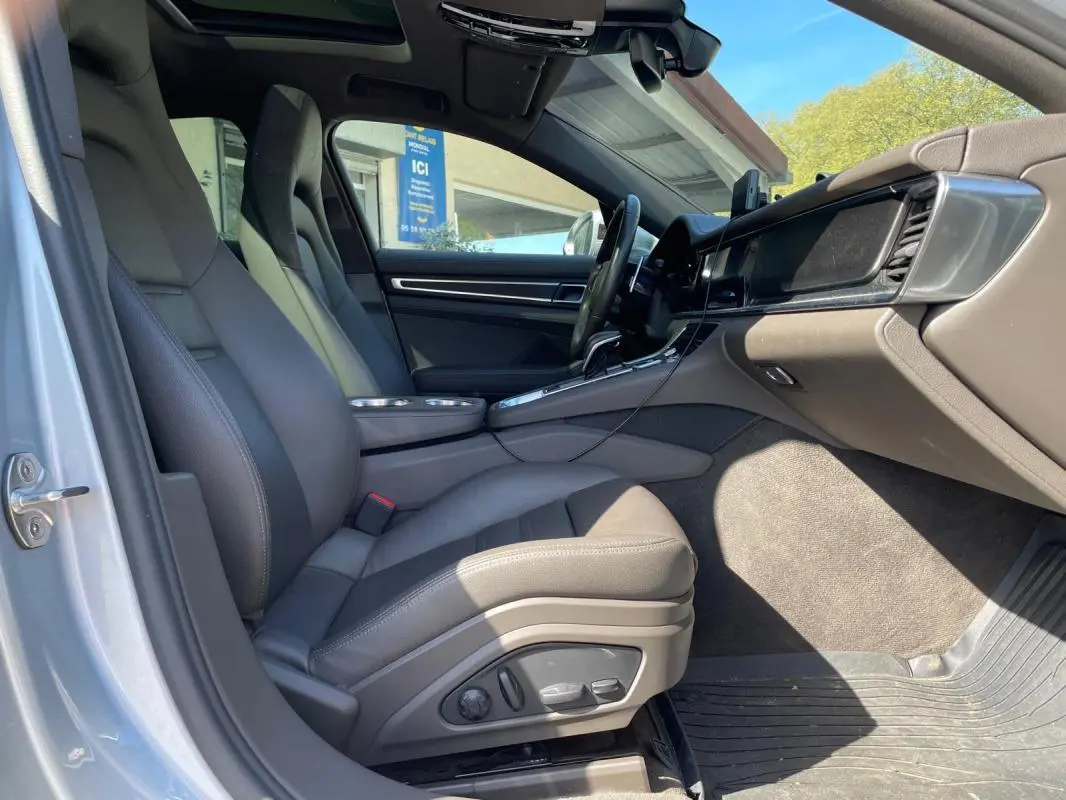 Vue intérieure côté conducteur de la Porsche Panamera 4 V6 Hybrid 2022 avec sièges gris et tableau de bord moderne.
