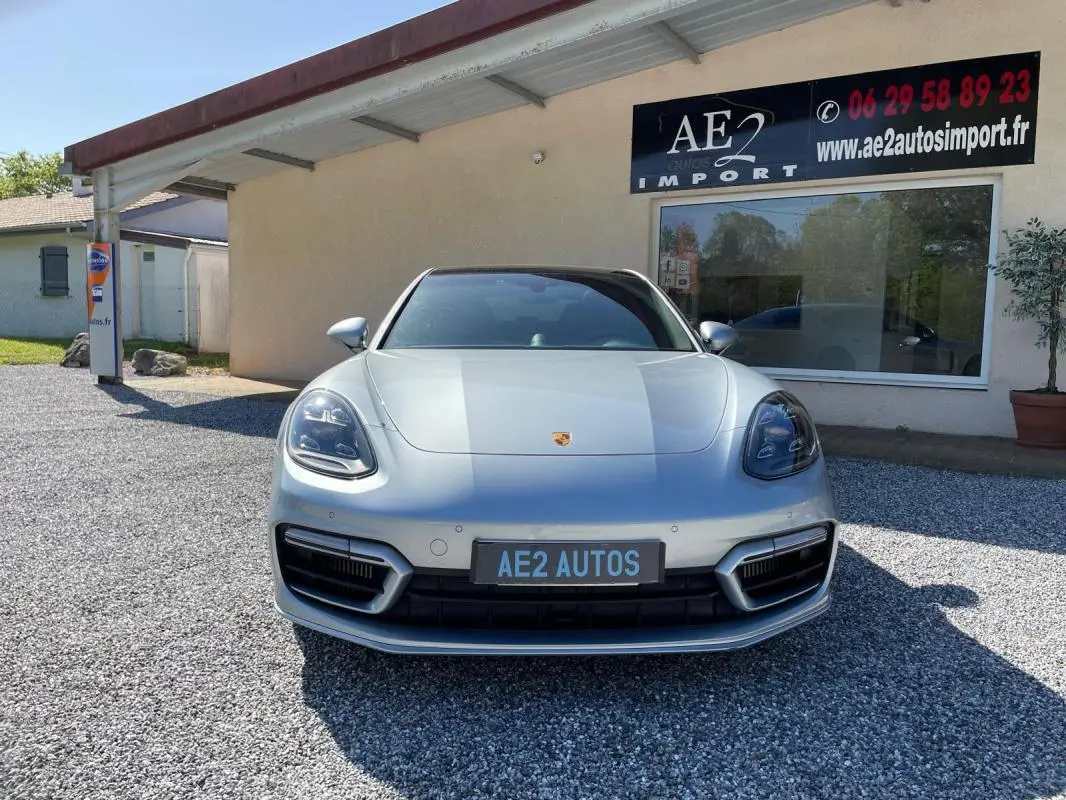 Vue frontale d'une Porsche Panamera 4 V6 3.0 Hybrid Platinum Edition gris métallisé, avec calandre et phares distinctifs.