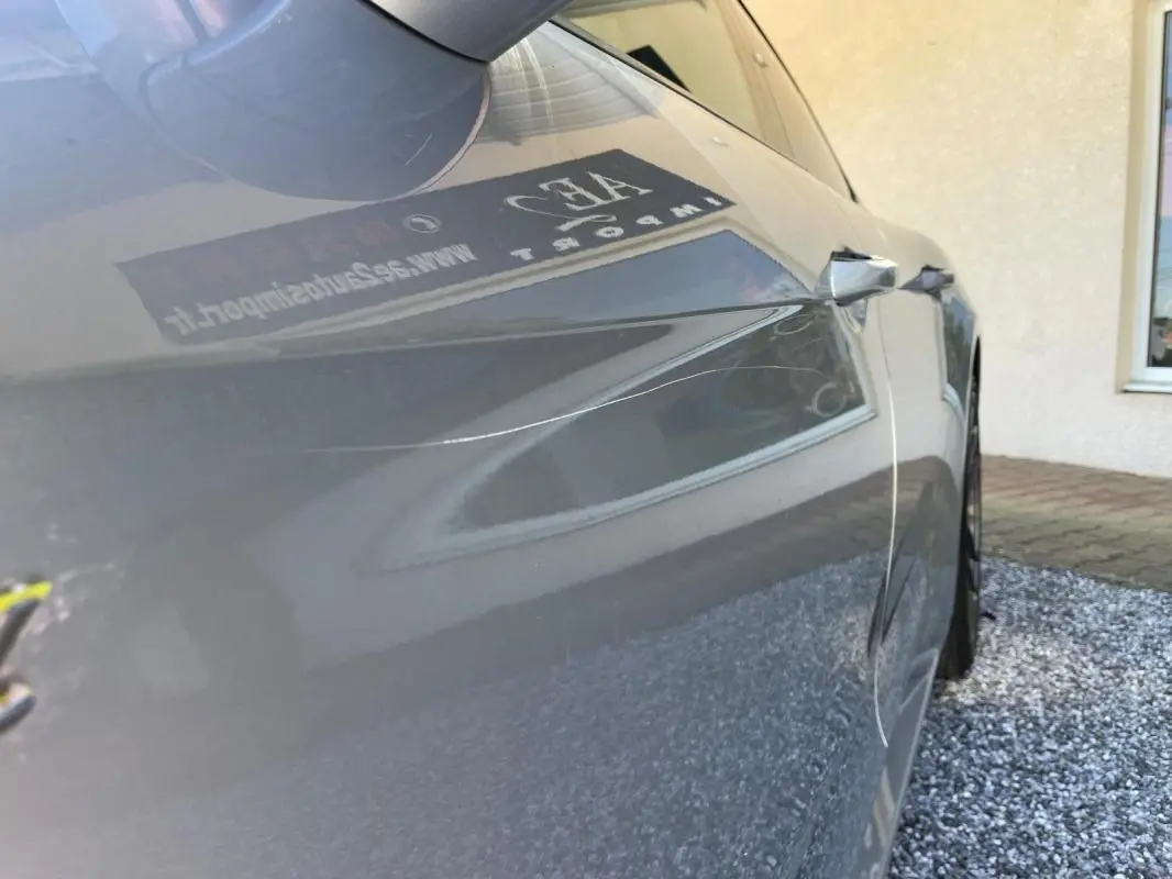 Vue rapprochée du côté gauche d’une Porsche Panamera gris métallisé 2022, mettant en valeur la carrosserie lisse et brillante.
