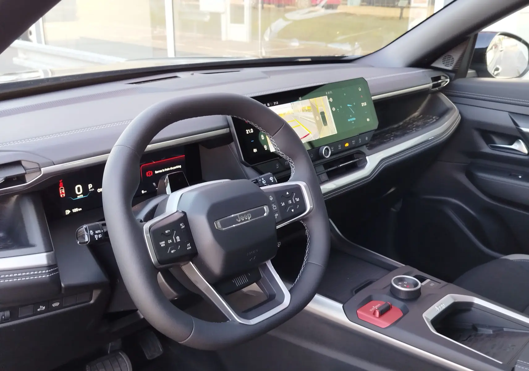 Vue intérieure côté conducteur du Jeep Compass noir Vulcano, avec volant multifonction et écran tactile large.