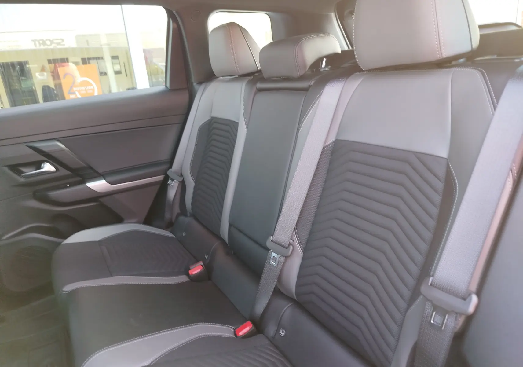 Vue intérieure des sièges arrière en cuir noir et gris du Jeep Compass MHEV 145CH BVA Altitude, avec ceintures de sécurité visibles.