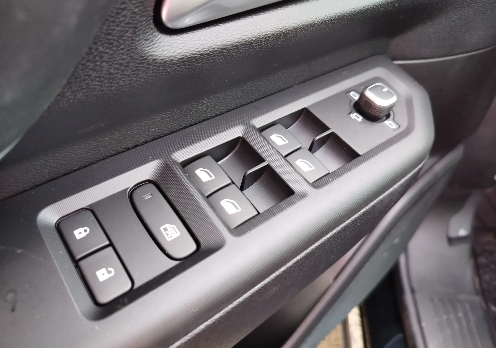 Gros plan sur les commandes de lève-vitres et rétroviseurs côté conducteur du Jeep Compass noir Vulcano 2026.
