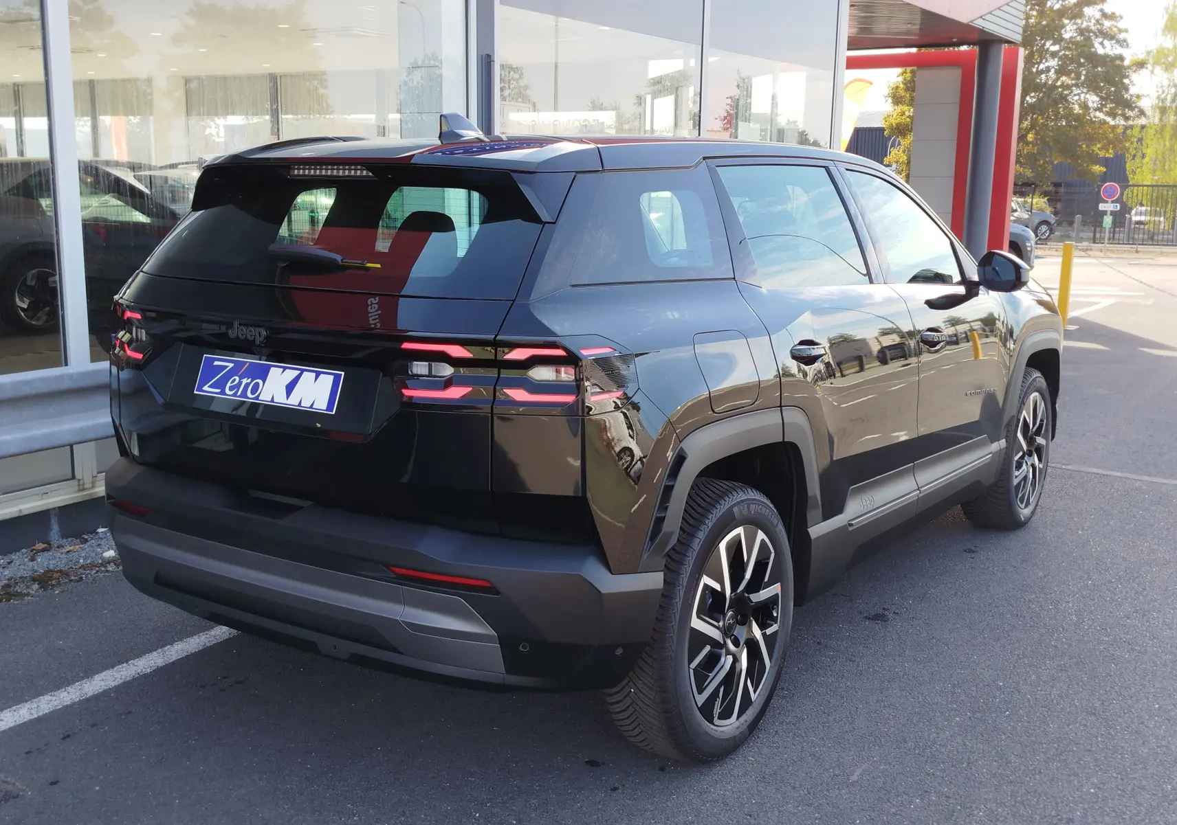 Vue 3/4 arrière droite du Jeep Compass noir Vulcano métal 2026 avec feux arrière LED et jantes alliage.